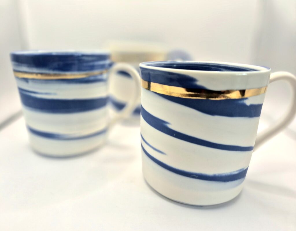 Blue and white porcelain mugs with gold rims by Rosa Morris at Sandgate Ceramic